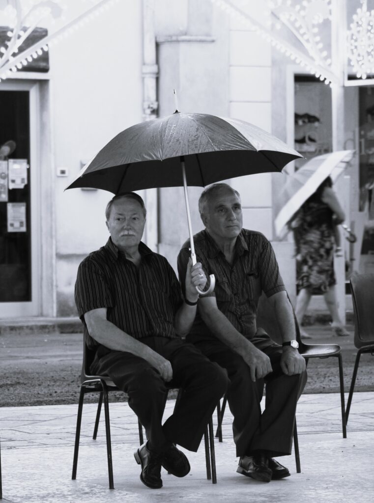 Petits vieux sous un parapluie en noir et blanc